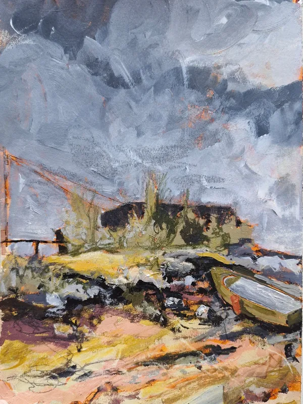 A small boat pulled up among rocks and yellow grasses, dark roofs beyond, under a heavy grey sky