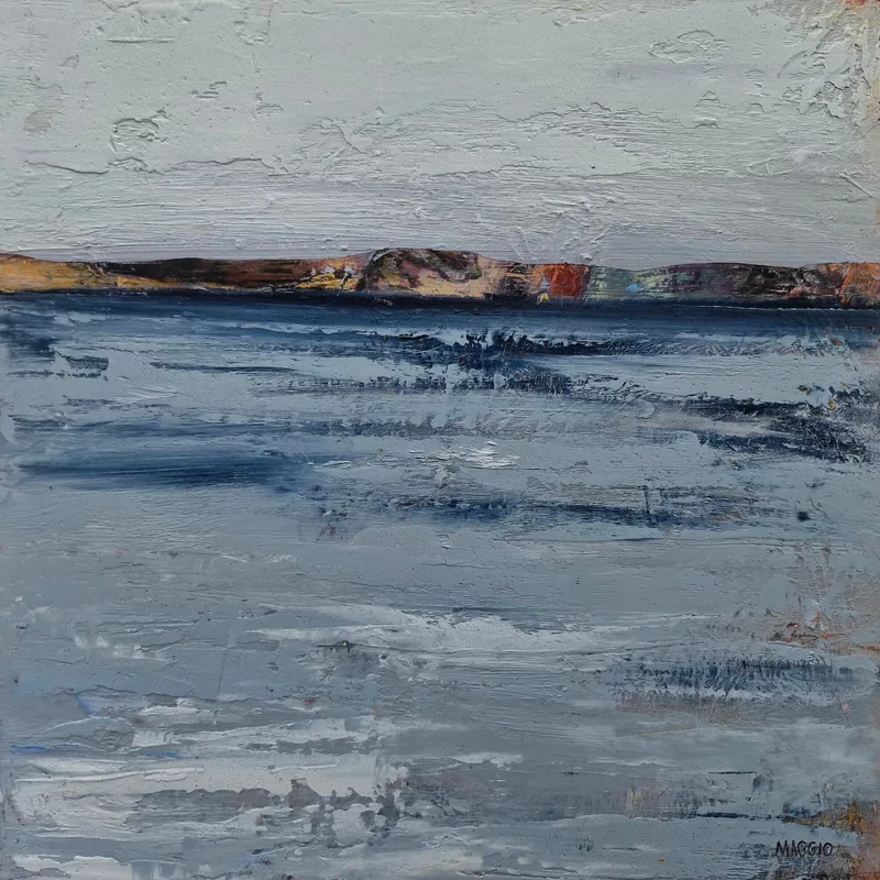 Calm grey blue water stretching to a thin strip of coastline under a pale, heavily textured sky
