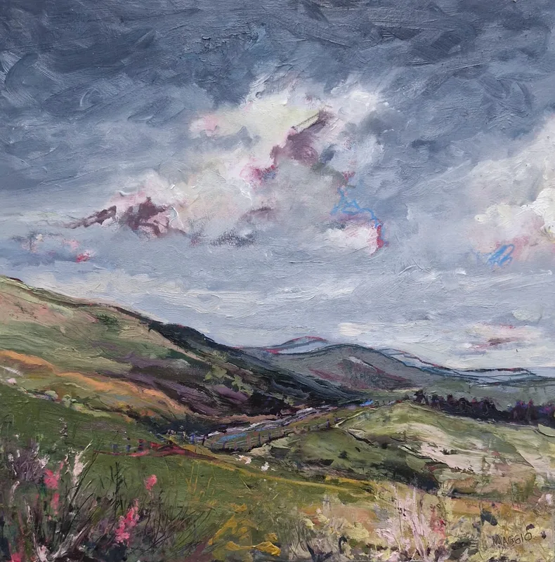 Green hillsides folding down into a valley, pink flowers in the foreground and pink edged clouds in a grey sky