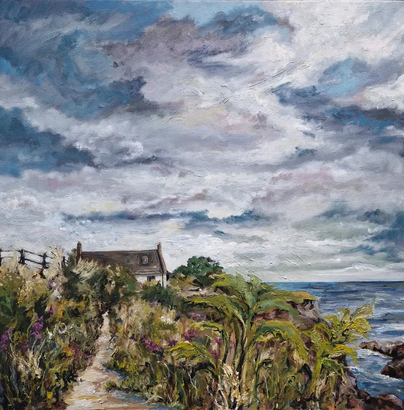A narrow path through tall green plants leading to a stone cottage on the cliff edge above the sea, under a stormy grey sky